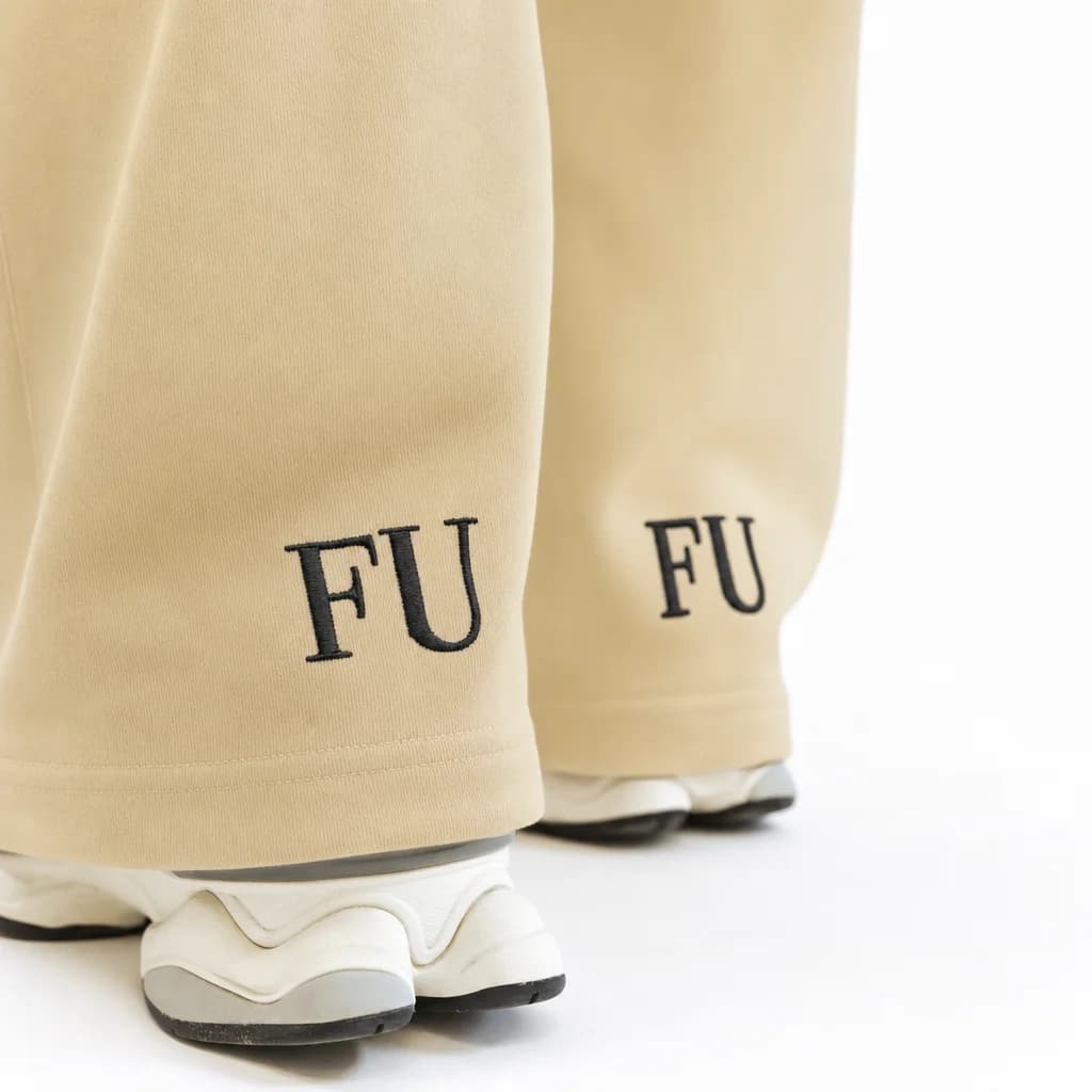 Embroidered FU monogram on the back hem of the beige wide-leg sweatpants